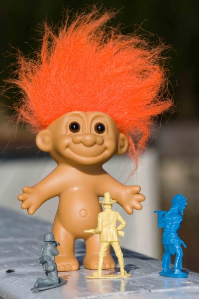 Troll doll surrounded by toy soldiers
