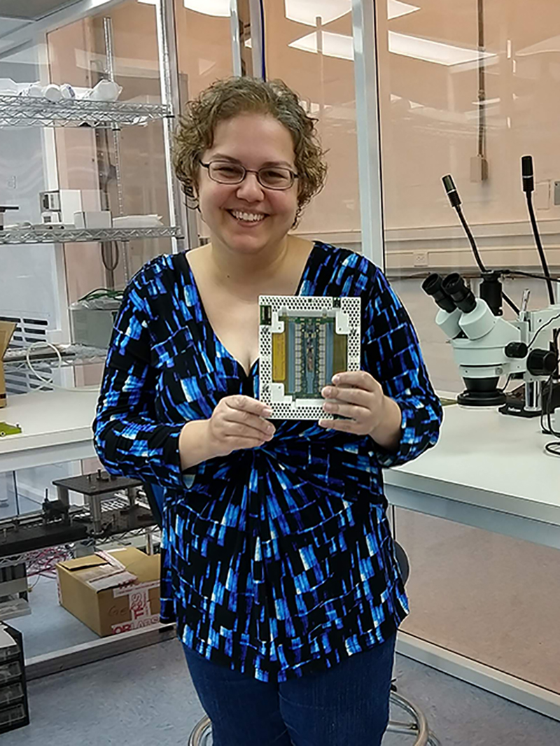 Catherine Nicoloff holds a silicon detector module in a lab at Brookhaven National Lab on Long Island.