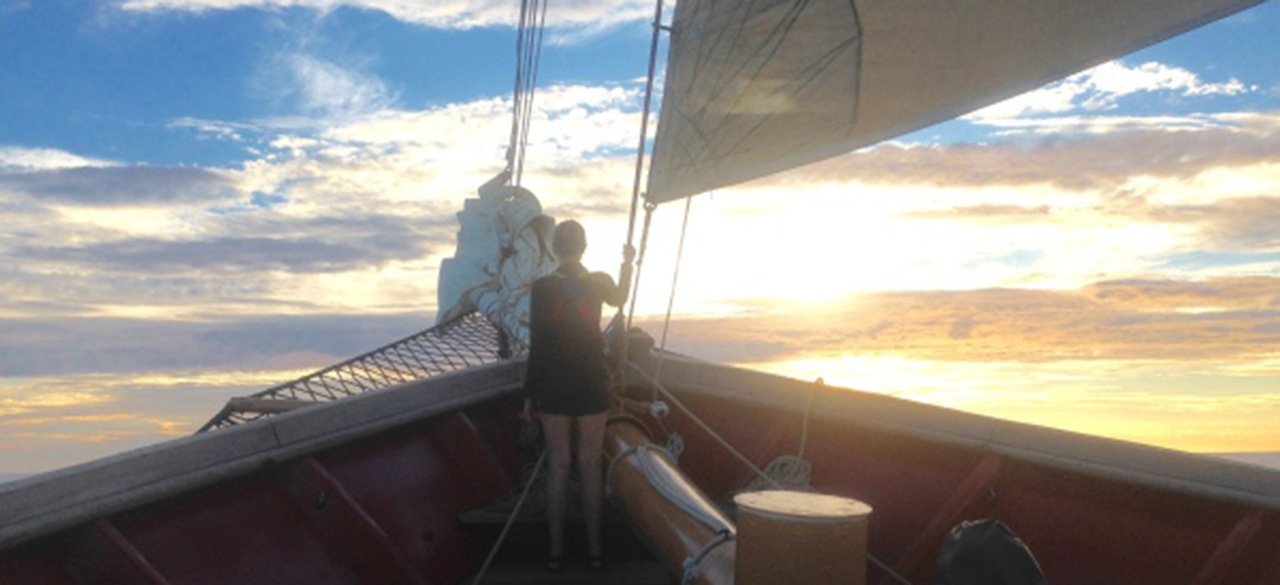 Anthea Fisher ’17 watches the sun set over the Mediterranean Sea from the bow of the SSV Corwith Cramer. 