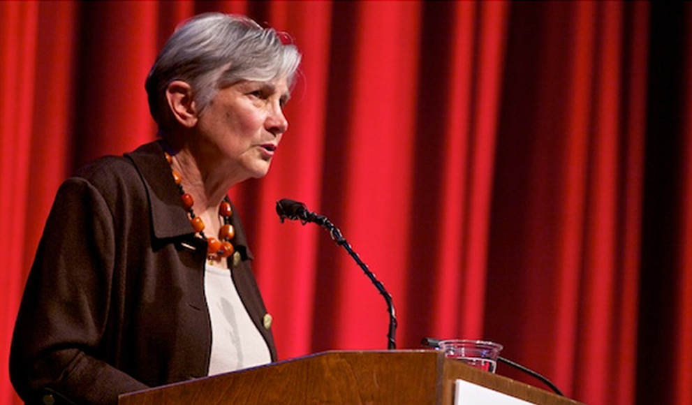Diane Ravitch ’60 speaking on stage in front of a red curtain