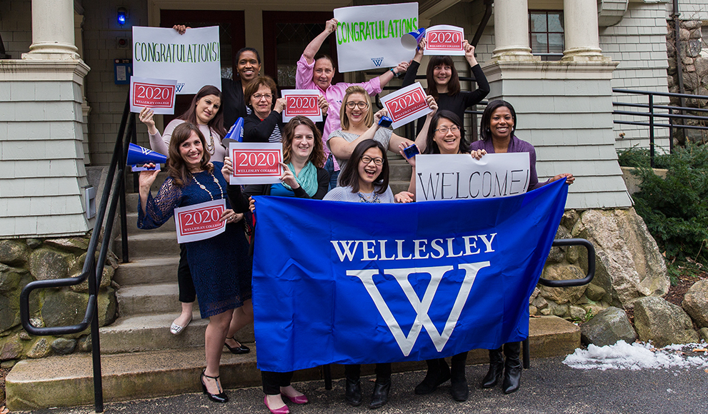 The Admission Office team holds signs welcoming newly-admitted students.