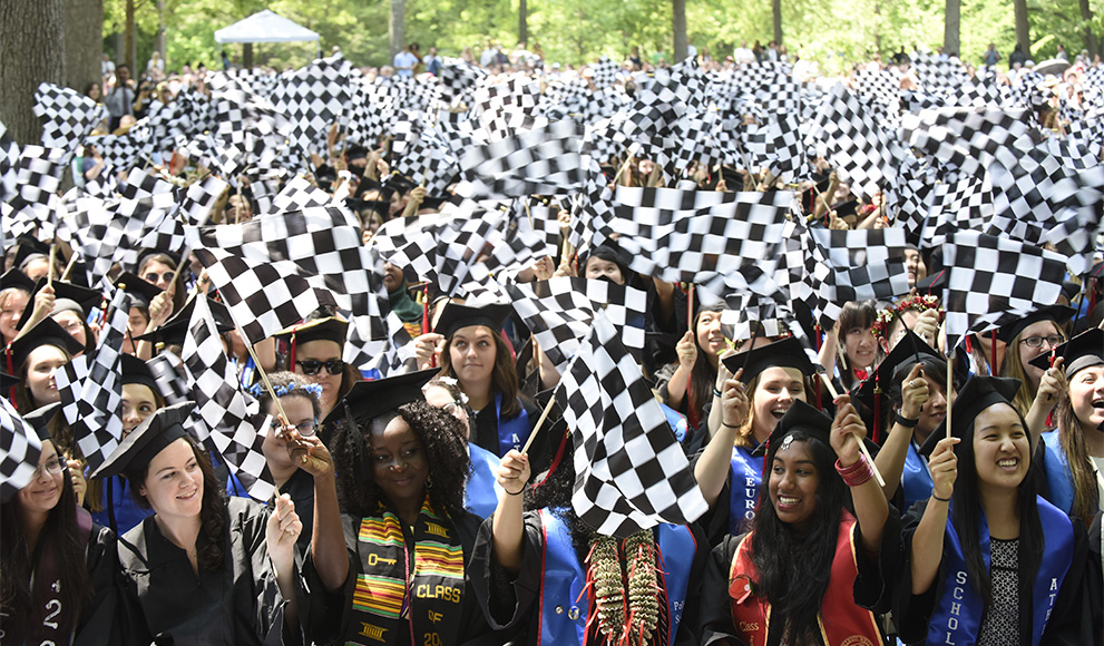 Students cheer and wave checkered flags