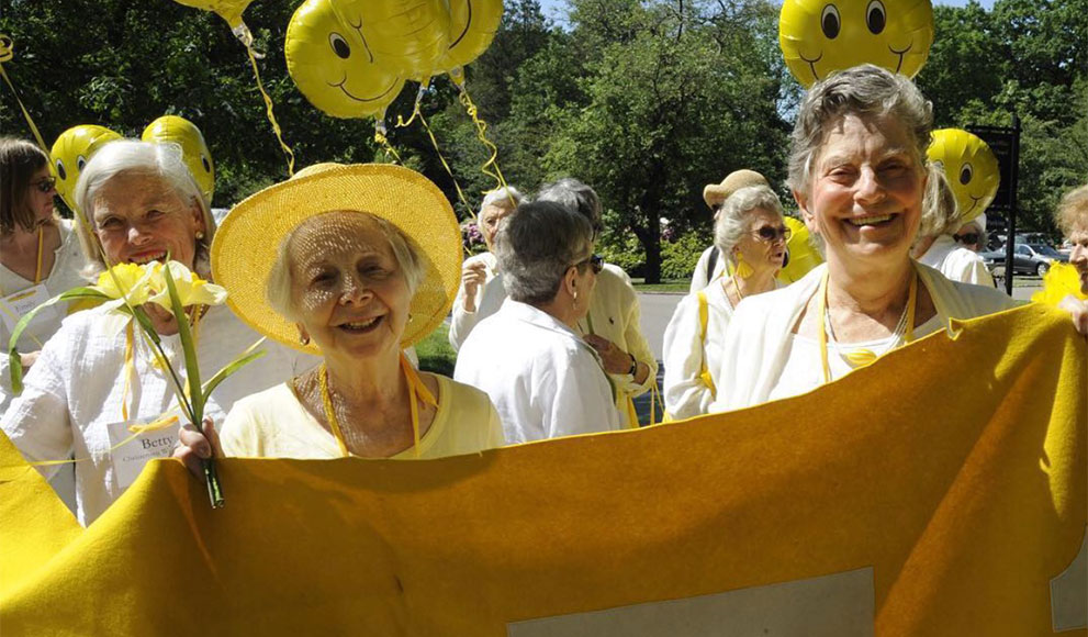 Wellesley alumnae hold a yellow class banner. 