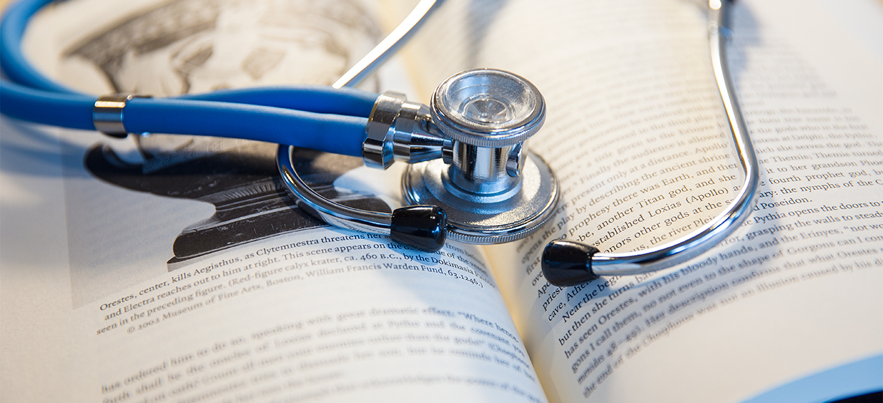 A stethoscope rests on an open book.