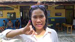 woman showing ink-stained finger proving she has voted