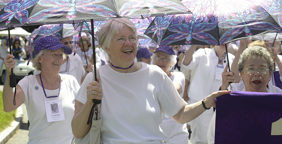smiling silver-haired alums from a purple class march in parade