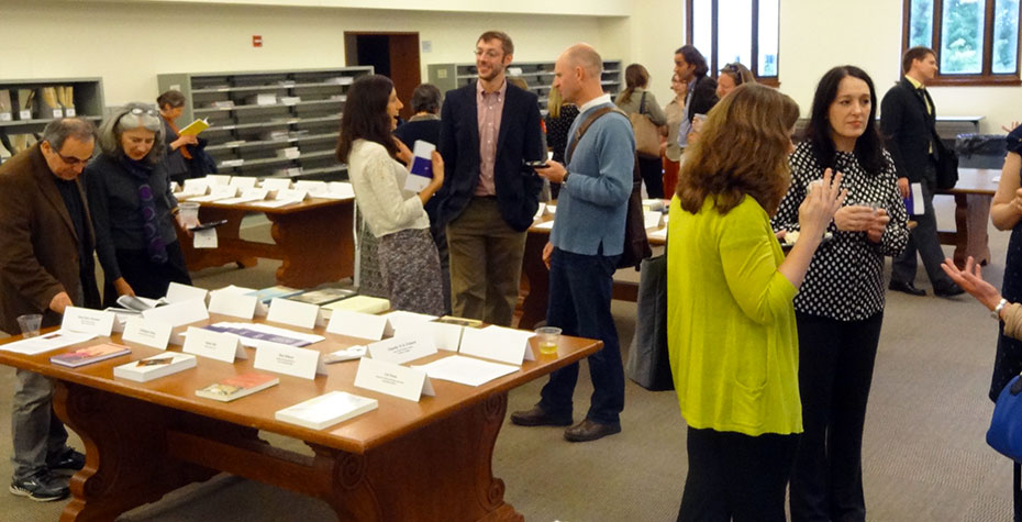 faculty talk, laugh, and look at printed pages together in Clapp reading room