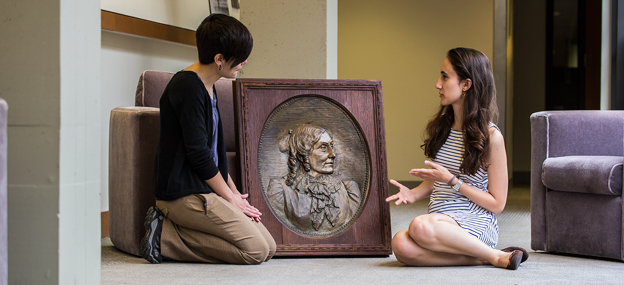 College Archivist Jane Callahan and Student Kathryn Cooperman discuss a bronze relief that was recently located in the College Archives after a months-long search.