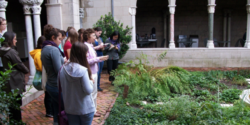 Students take notes as the teacher explains the plants in front of them 