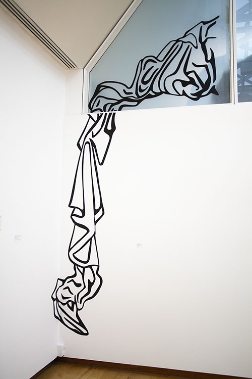 corner of a white wall gallery with trapezoidal window at top right; black vinyl installation on the wall and window, thick lines that look like cartoony fabric bunched up in the window and cascading down the wall nearly to the floor