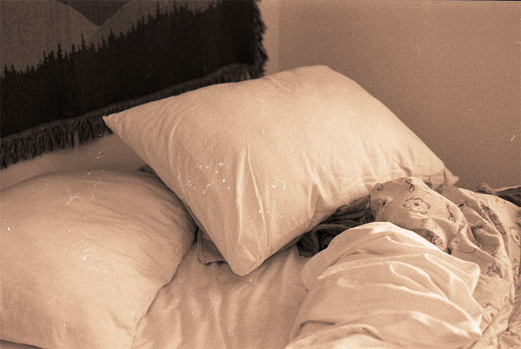 warm-toned photograph of white pillows on a bed