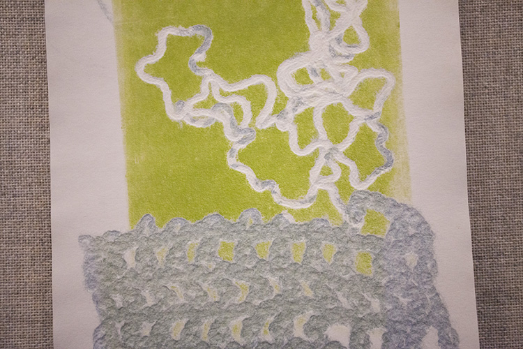 close up on a print with lime green background, white yarn print above and pale blue net yarn print below