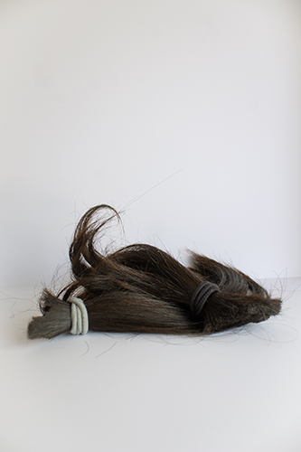 several hanks of cut-off dark hair with elastics
