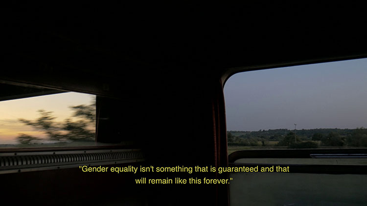 shot with two framed windows, one showing blurred landscape with low sun, the other showing blue sky and unblurred landscape; yellow text at bottom reading "Gender quality isn't something that is guaranteed and that will remain like this forever."