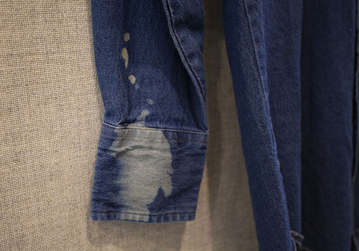 white laser engraving of a spatter on the sleeve of a denim shirt