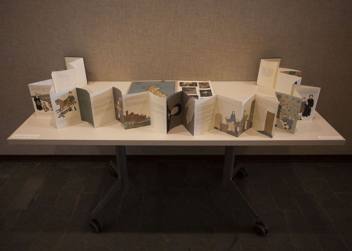 a white table with a very long accordion book opened across it