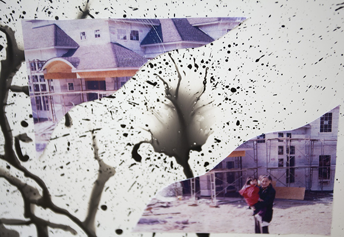 a deconstructed photograph of a woman holding a child in front of a building. In the background is photo emulsion splatter