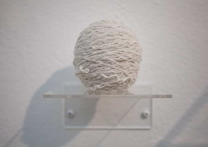 a ball of white yarn on a clear shelf