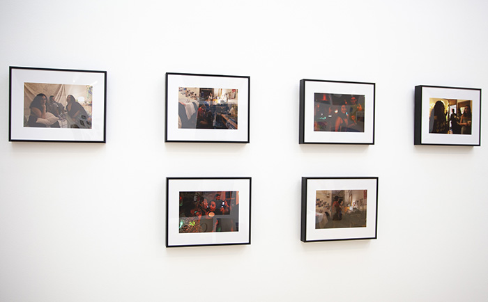 6 color photographs with white mats and thin black frames installed on a white wall
