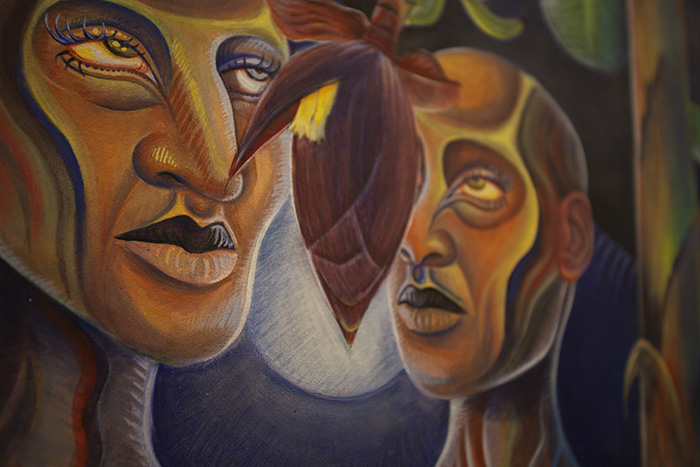 close-up of a painting of two stylized faces with a purplish plant bud between them