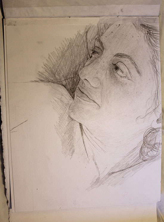 a pencil drawing of a face; hints of other paper stacked behind indicate that this is one page in a series