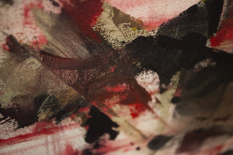 close up of the surface of an abstract painting in shades of red and maroon