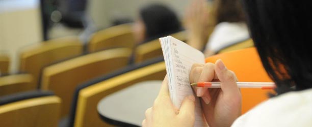 closeup of hands making list in notebook