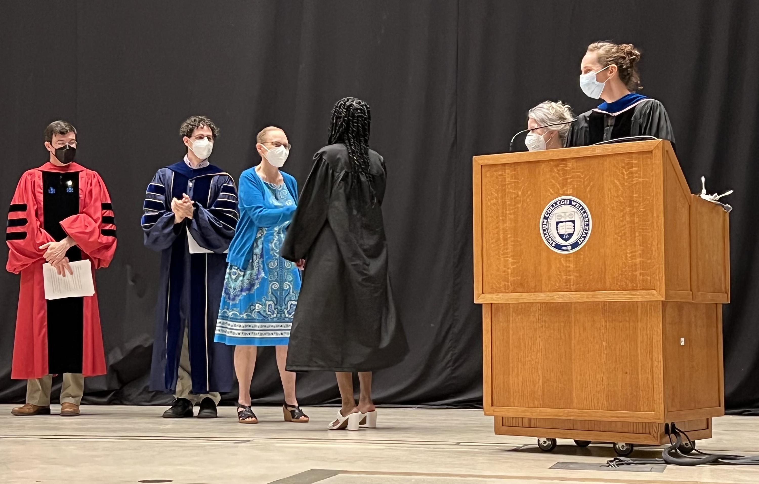 Photo of Corri Taylor on stage with recipient during award ceremony