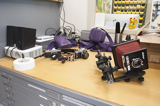 various cameras sitting on top of a flat file