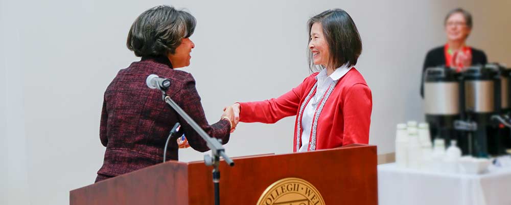 Employee shakes hand of college president
