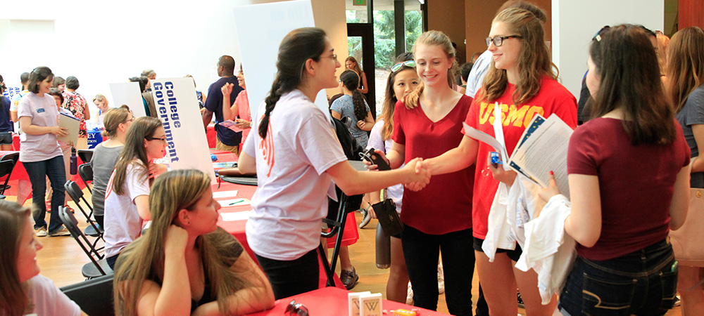 Students greeting each other at an organization fair