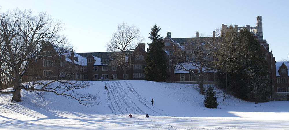 Students sledding down the snowy hill 