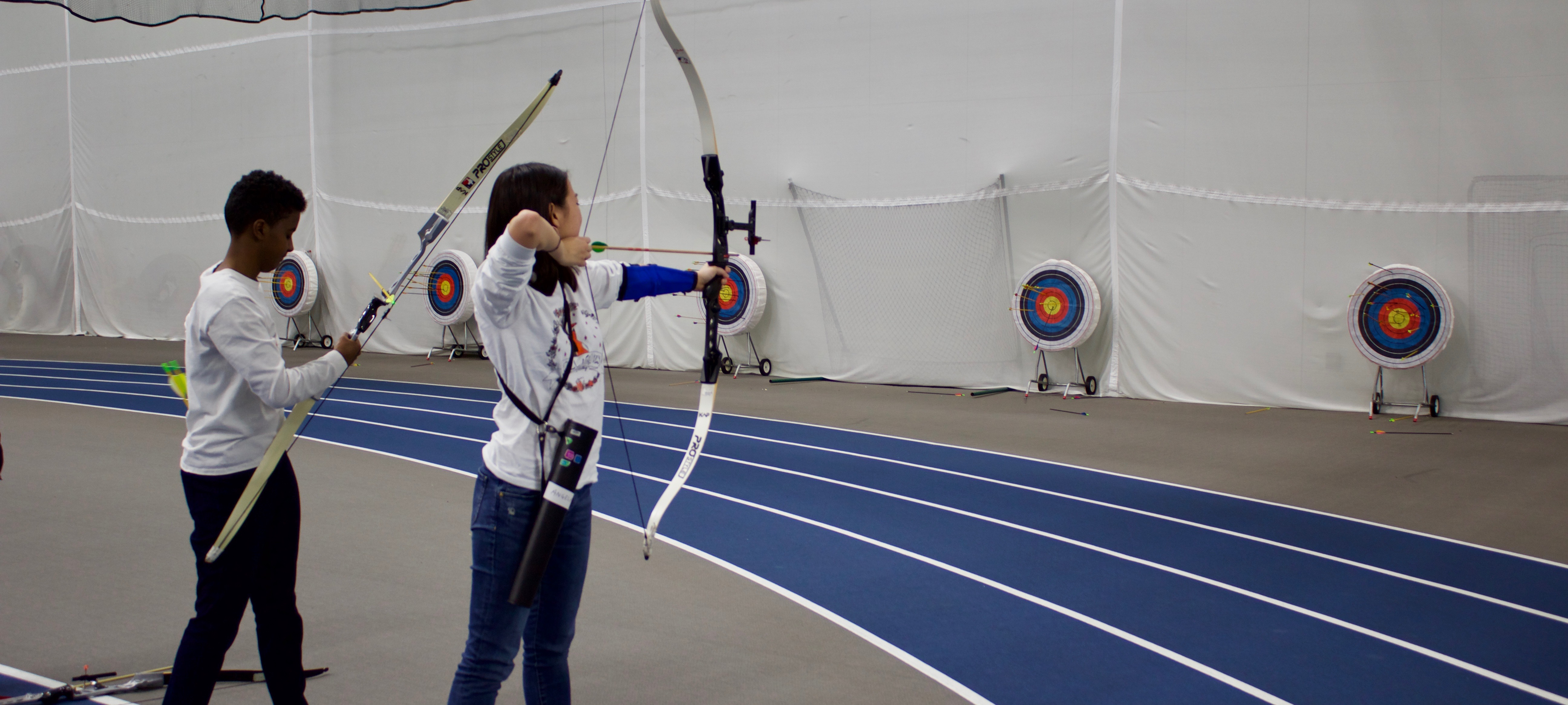 students taking aim at a target in an archery class