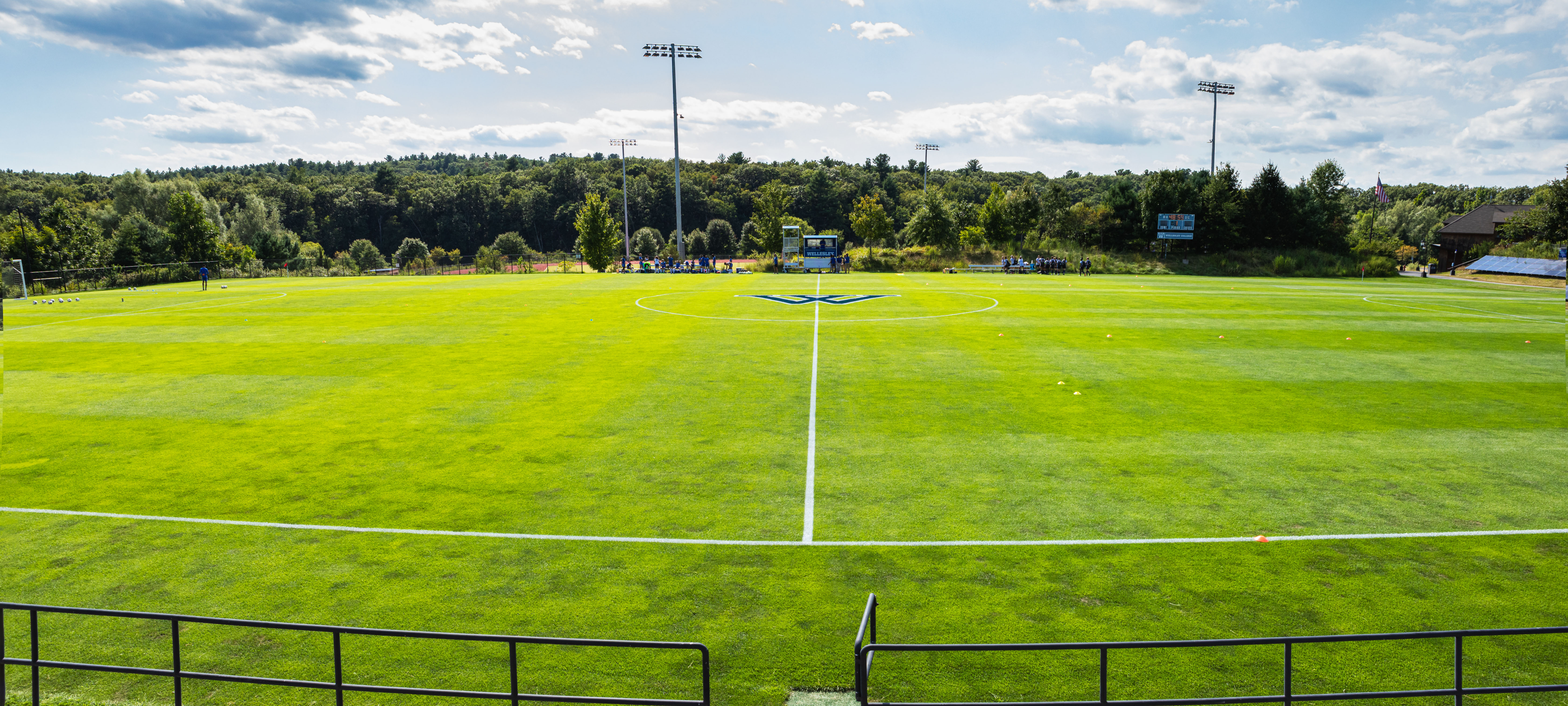A wide shot of the soccer field with a blue Wellesley W painted in the middle 