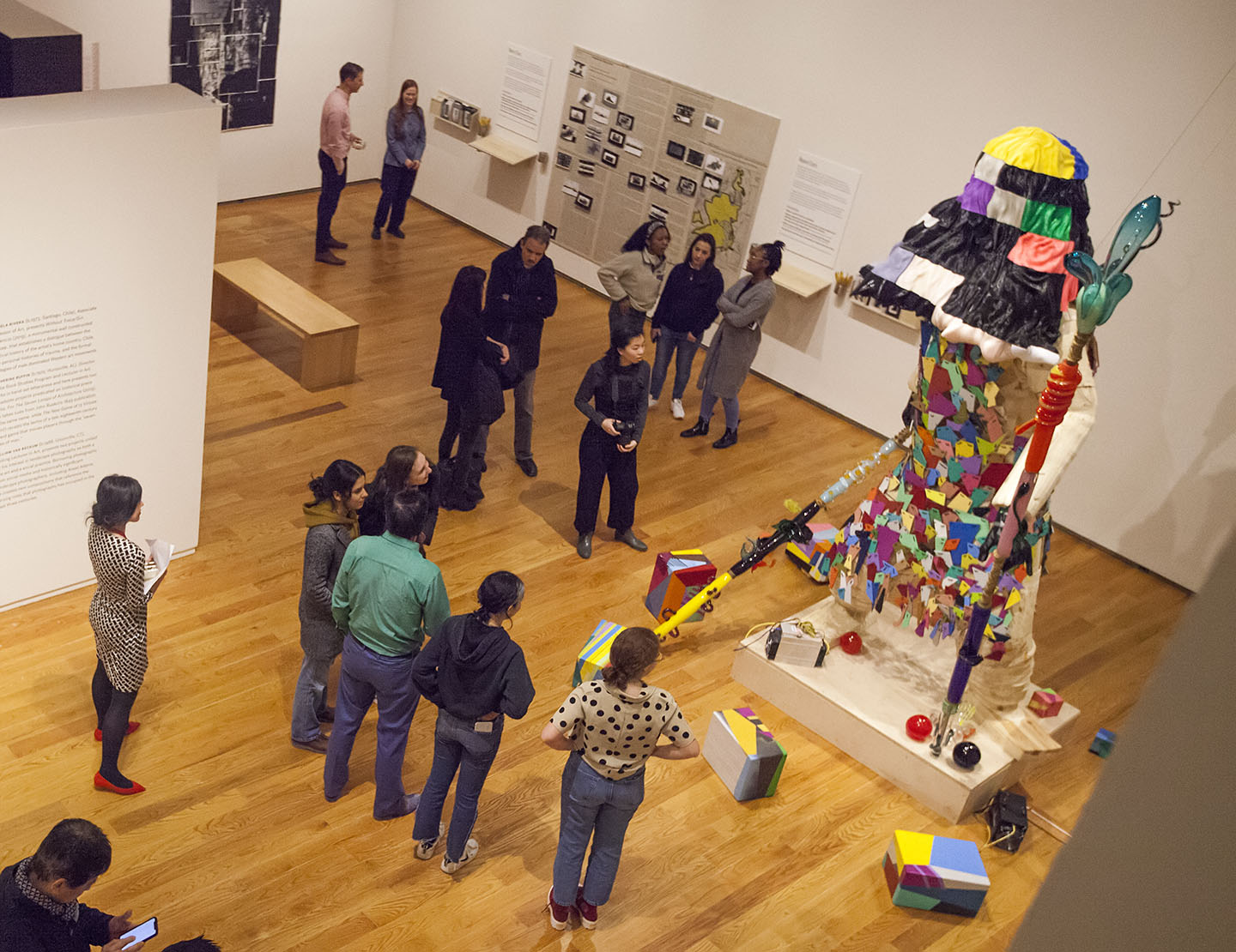 people looking at large figurative sculpture, gallery photographed from above