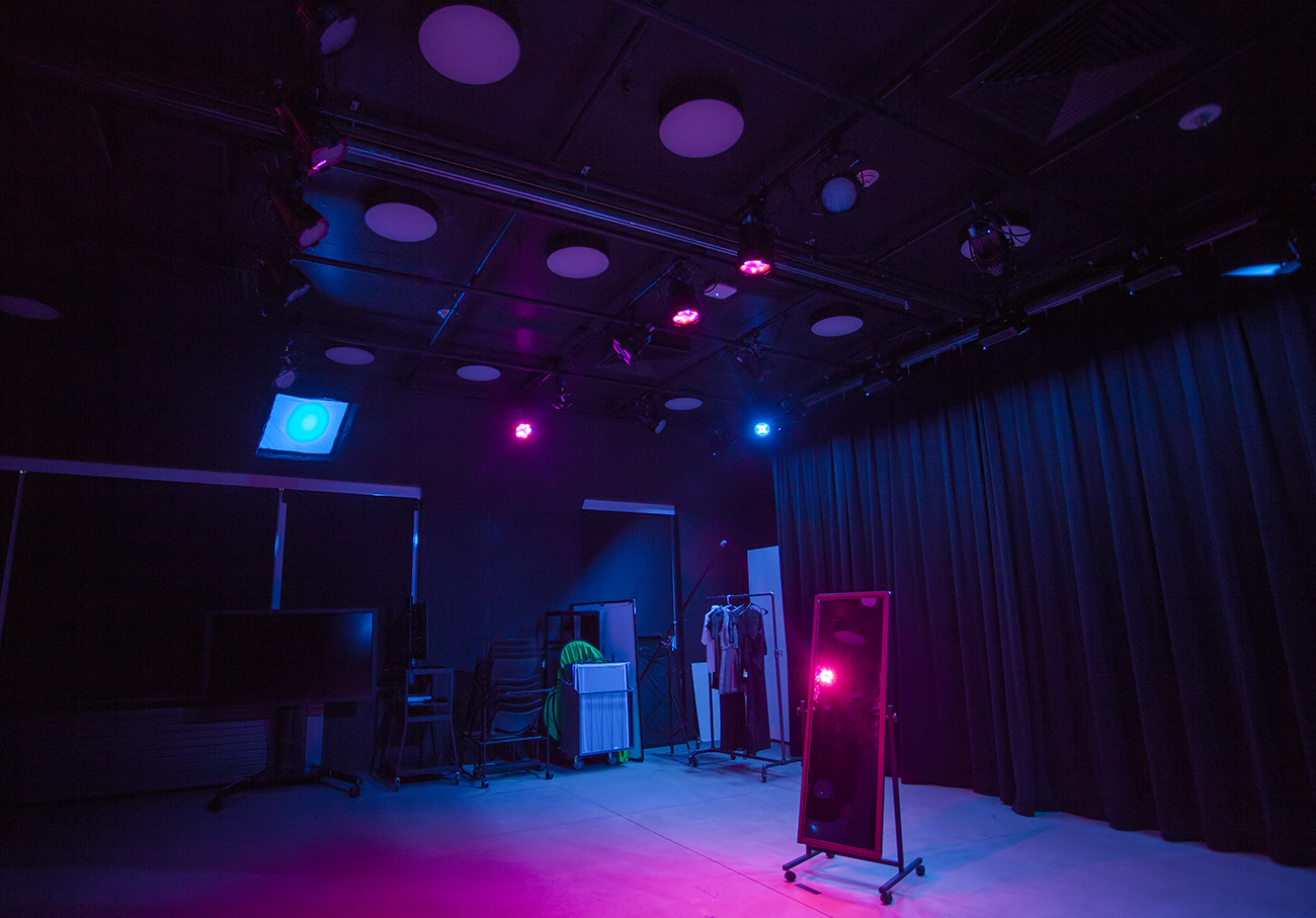 lighting studio with magenta and blue lights, stand up mirror in middle of room