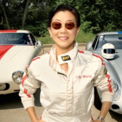 Lulu Chow Wang in front of two of her racecars