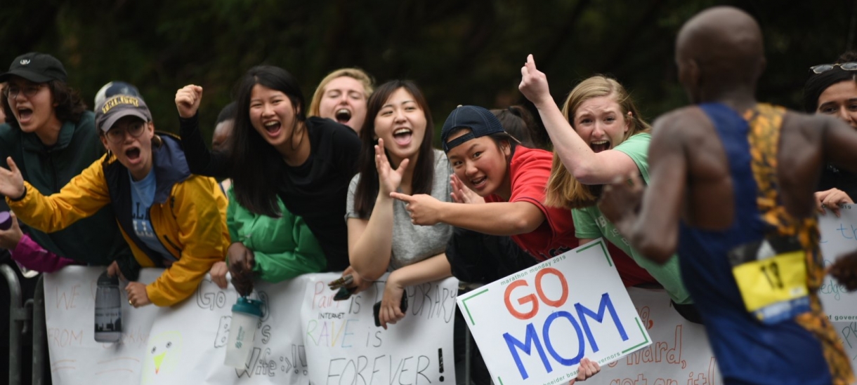 modern day students cheering with signs in the Scream Tunnel