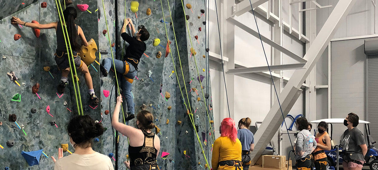 A group of students climbing and belaying
