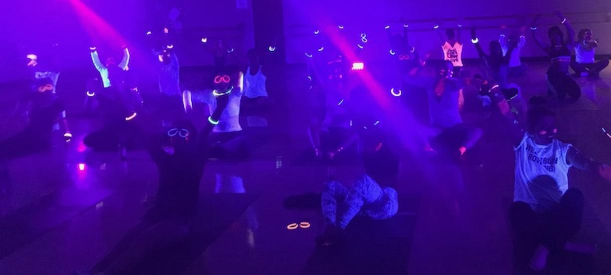 A picture of students doing yoga and glowing in the dark
