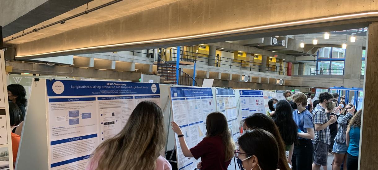 Participants in the 2022 SC SRP Poster Session look at and discuss their posters for their summer research projects