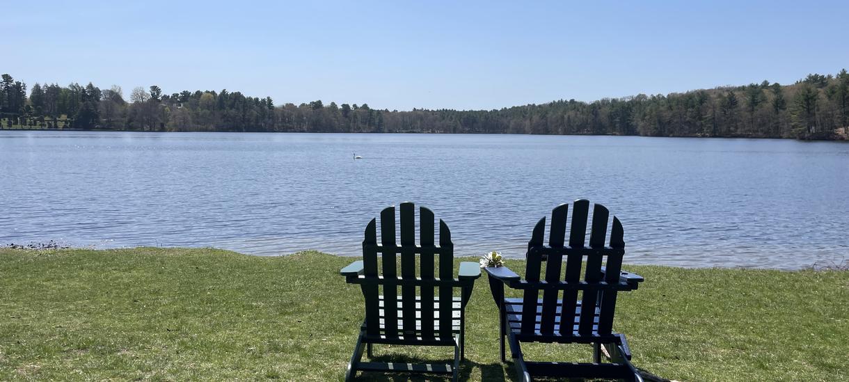 Adirondack chairs in front of Lake Waban