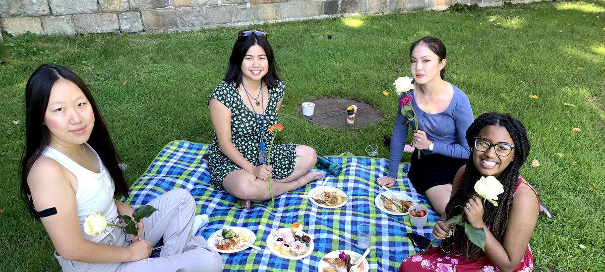 Students gather on a picnic blanket for Flower Sunday. 