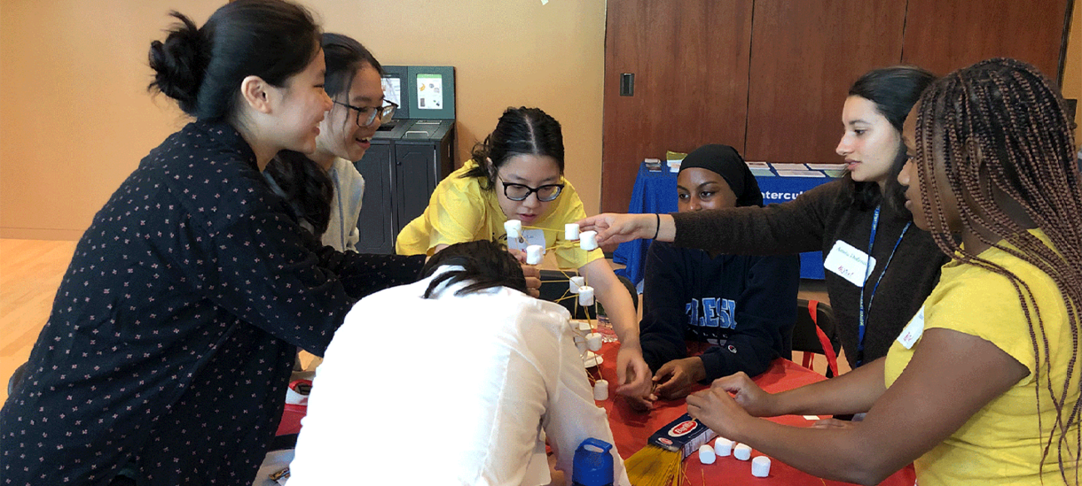 Students making a marshmallow-noodle structure.