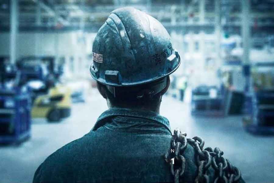 image of the back of a head of a person standing in a factory