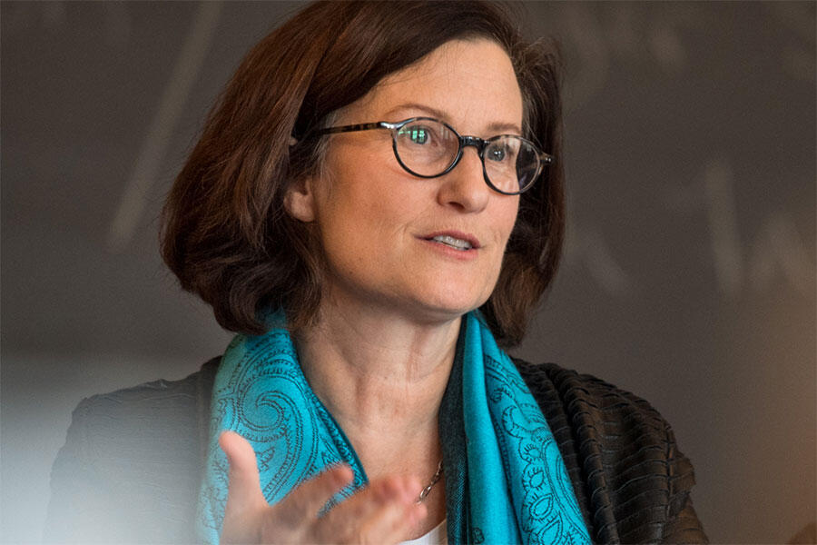 a woman speaking and gesturing with her hand