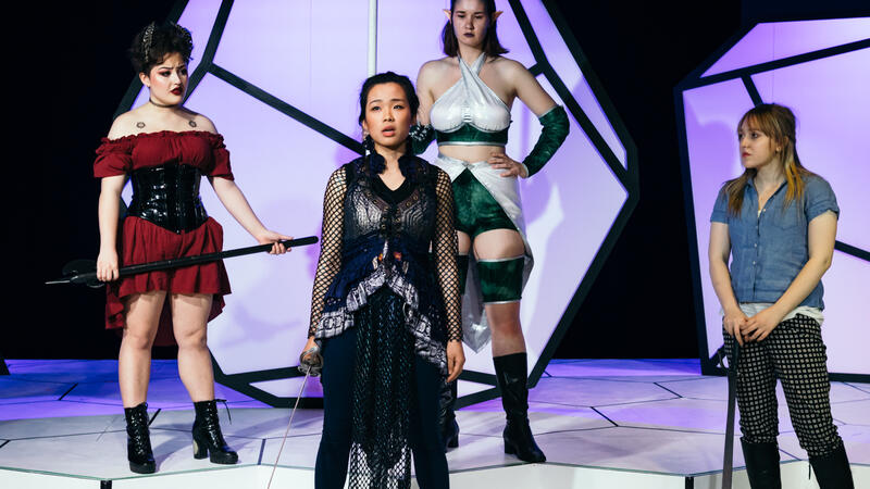 four actors in fantasy costumes standing on stage