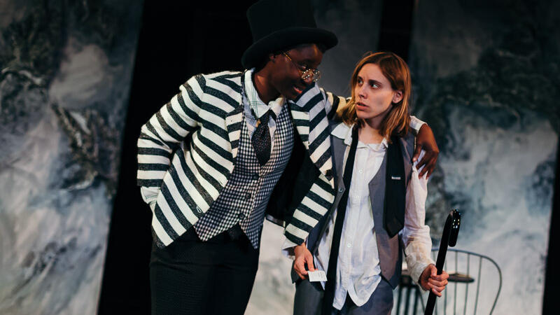 two actors in black white and grey clothing on set