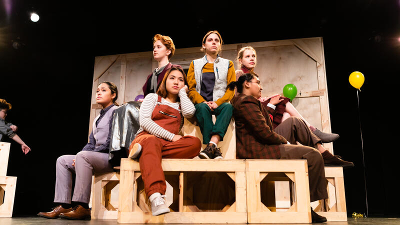 6 actors sitting on wooden structure