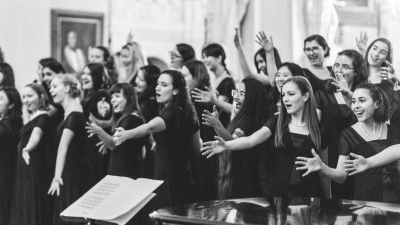 black and white photo of choir performing with hand motions